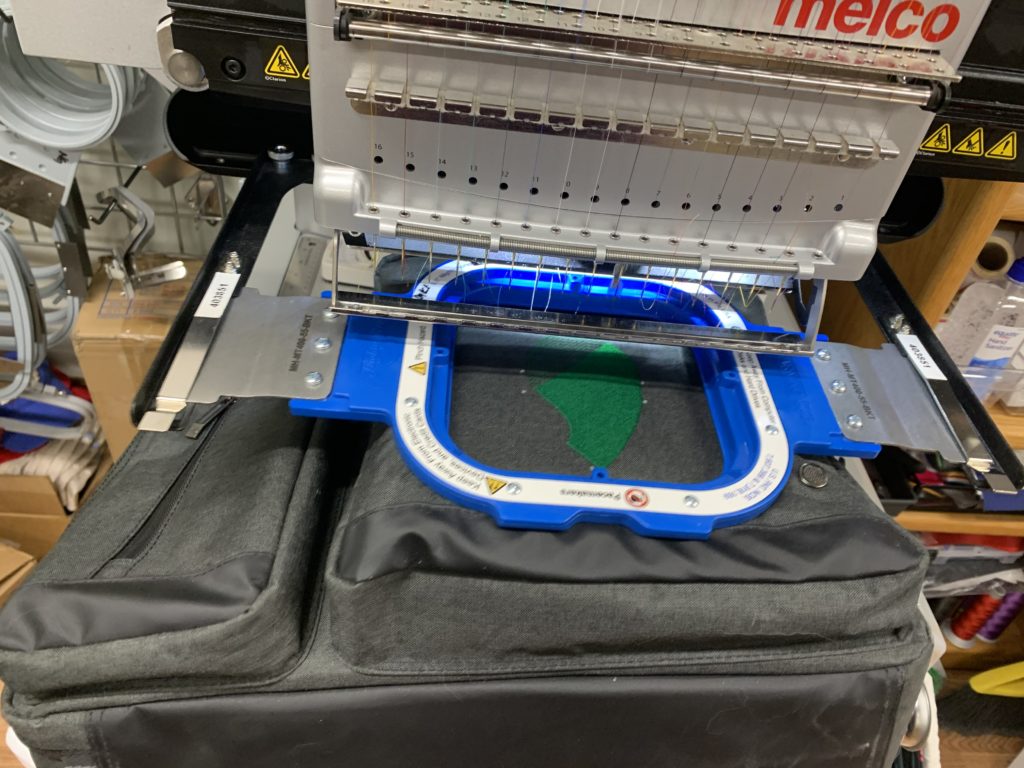 Automated commercial embroidery machine creating custom logo designs for businesses near Rifle, CO.